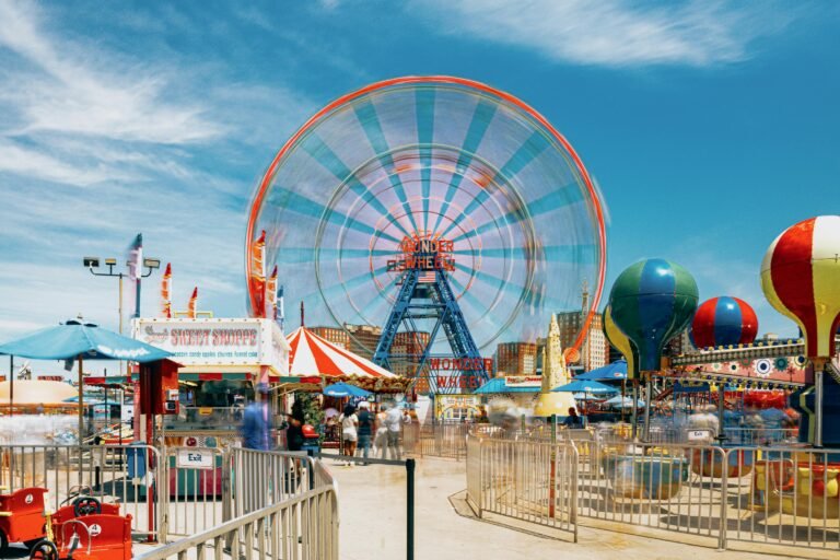 Vibrant scene of Ferris wheel and attractions at Coney Island, New York.